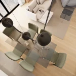 Pogled na blagovaonski stol iz ptičje perspektive. Stakleni blagovaonski stol i šest stolica u zelenom bukleu